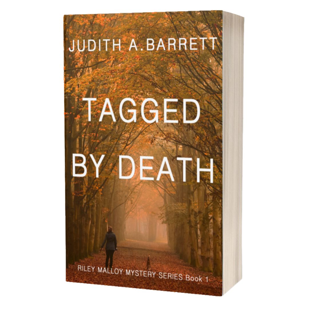 Book titled 'Tagged by Death' by Judith A. Barrett with a forest scene on the cover.