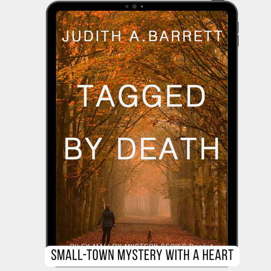 Book cover of 'Tagged by Death' by Judith A. Barrett with a person walking through a tree-lined path.