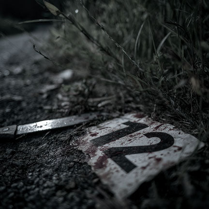 Rusted metal object with '12' on a dark, grassy ground